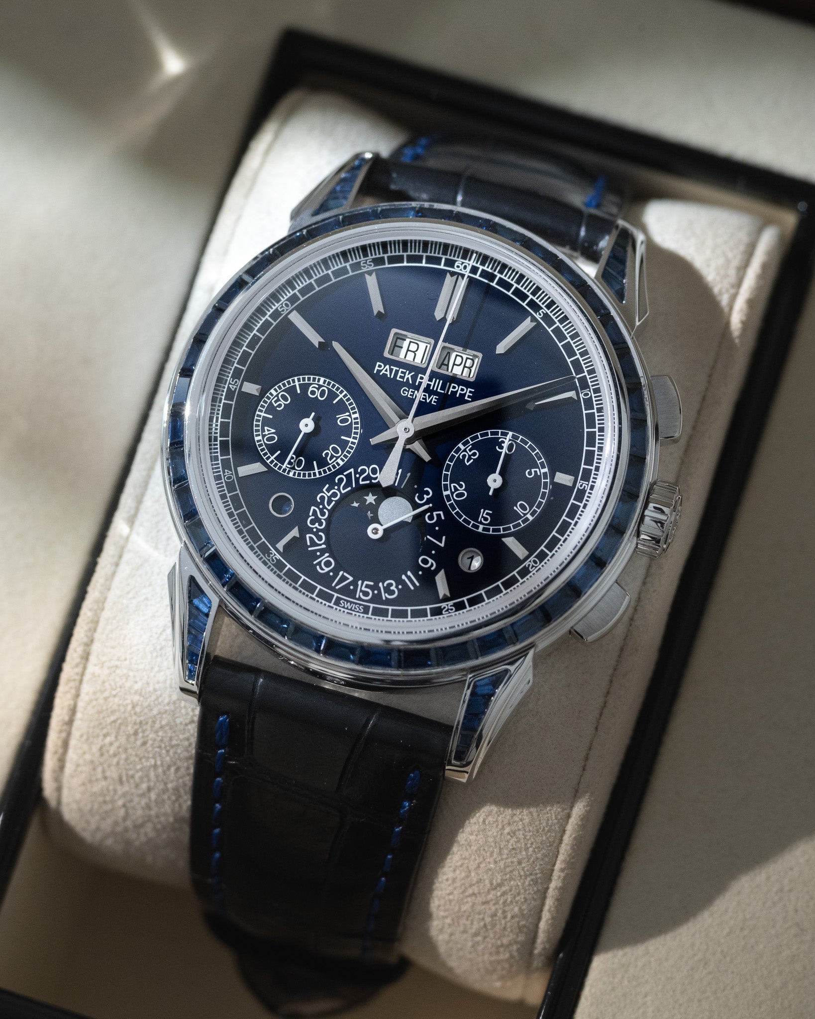 Luxury watch with blue dial and black strap in a box